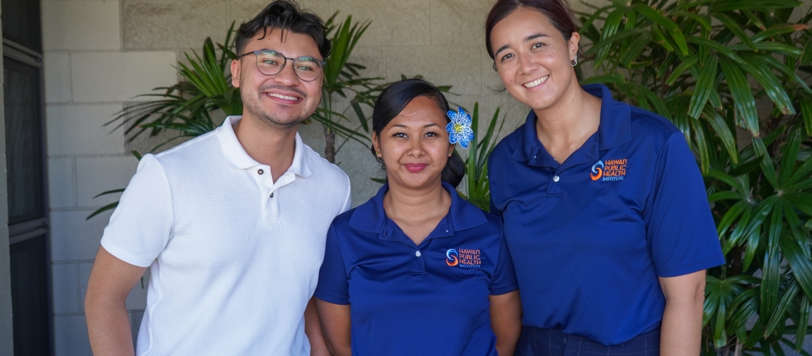 Javier Aguiniga with the WEST EJ Center poses with two employees of the Hawai'i Public Health Institute at a community outreach event.
